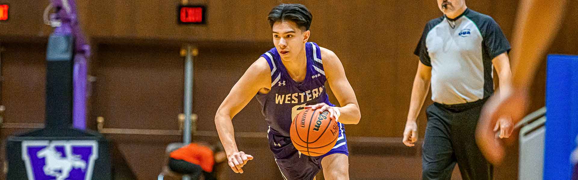 Western Mustangs men’s basketball player dribbling the ball