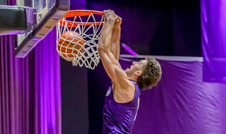 Western Mustangs men’s basketball player jumping and shooting the ball