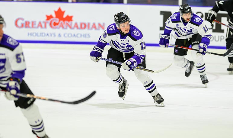 Western Mustangs men’s hockey player skating with the puck