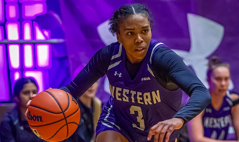 Western Mustangs women’s basketball player with their arms up defending a play