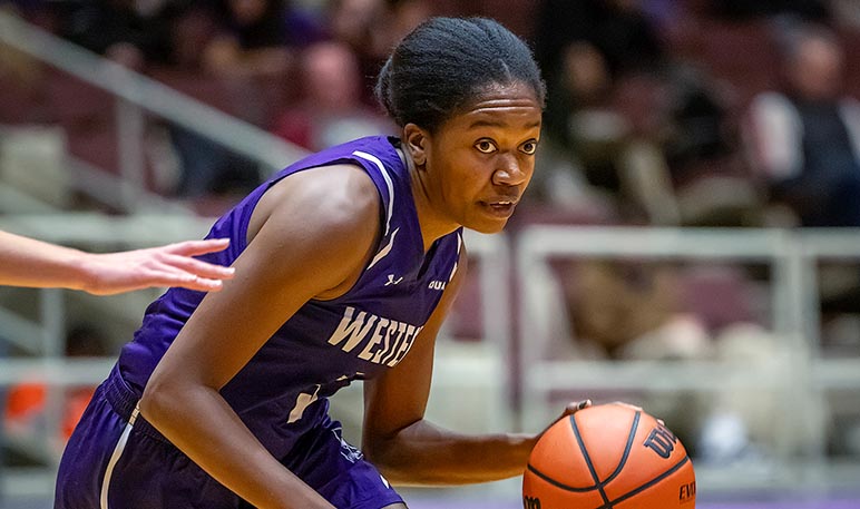 Western Mustangs women’s basketball player running and dribbling the ball