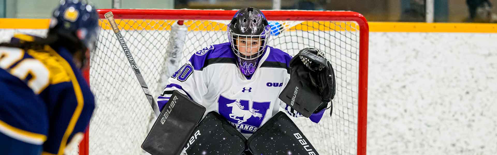 Western Mustangs women’s hockey player shooting the puck on net