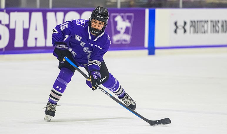 Western Mustangs women’s hockey player skating with the puck