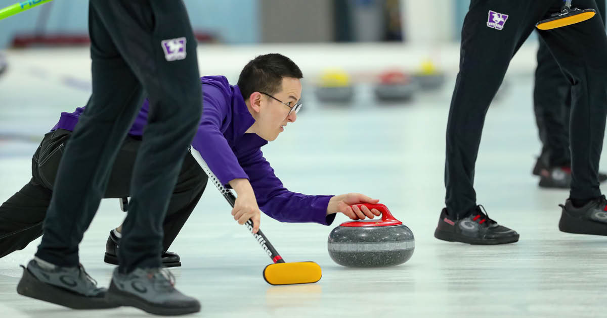 Western Mustangs men’s curler preparing to deliver a stone