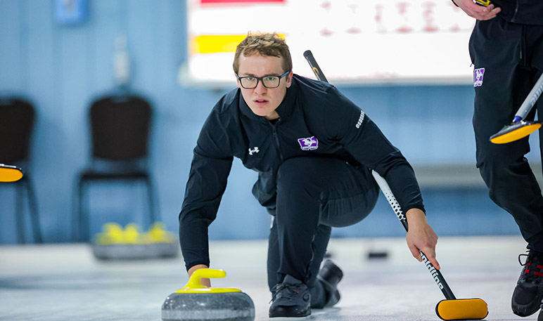 Western Mustangs women’s curlers sweeping the ice in front of a stone