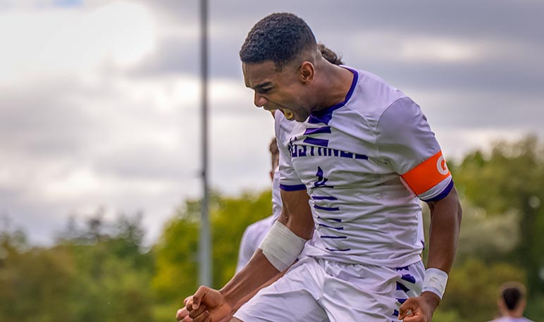 Western Mustangs men’s soccer player running in the rain