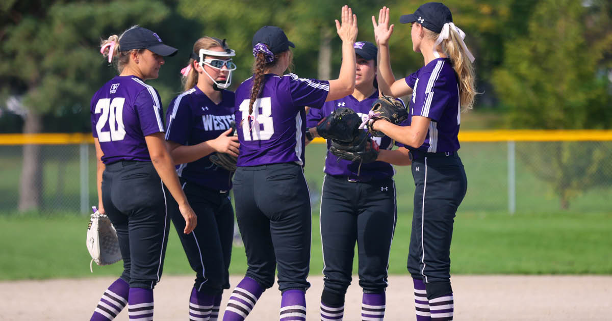 Western Mustangs softball players high-fiving in celebration