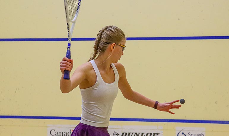 Western Mustangs female squash player mid-competition