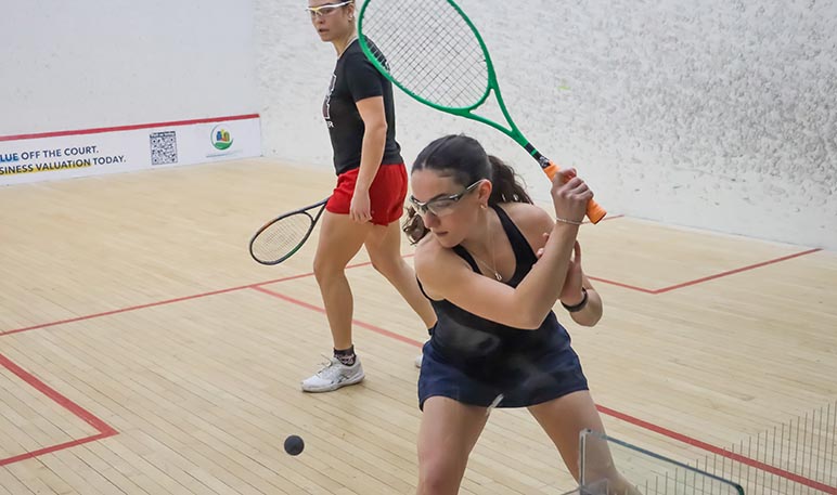 Western Mustangs female squash player mid-competition