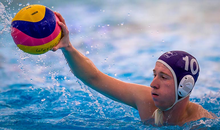 Western Mustangs water polo player holding the ball out of the water