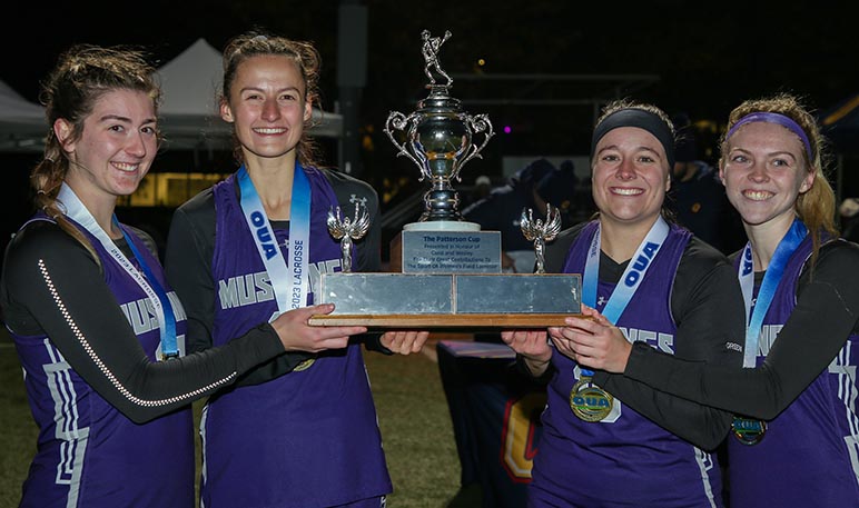 Western Mustangs women’s lacrosse player running with the ball