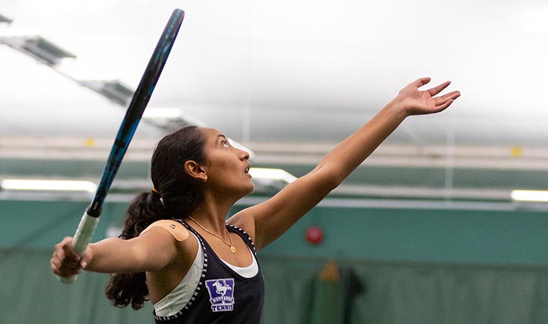 Western Mustangs women’s tennis player serving the ball