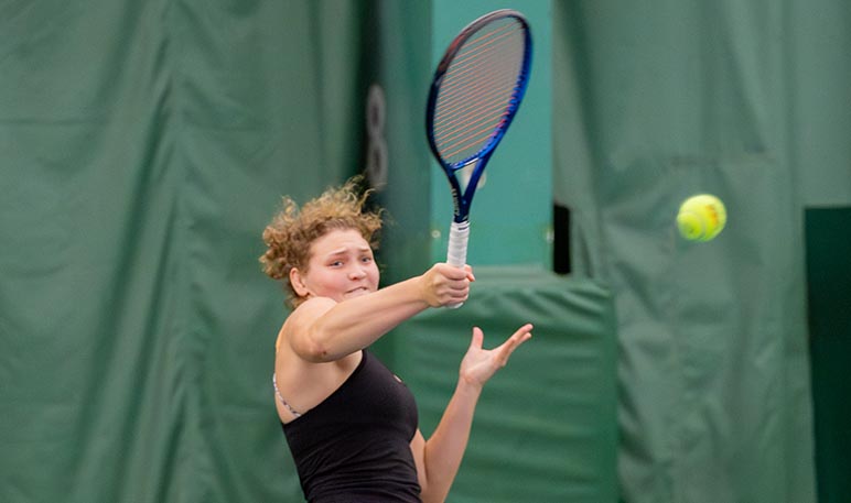 Western Mustangs women’s tennis player lunging to hit the ball