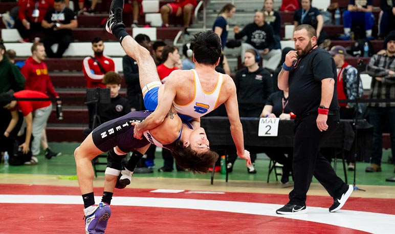 Western Mustangs male wrestler mid-competition