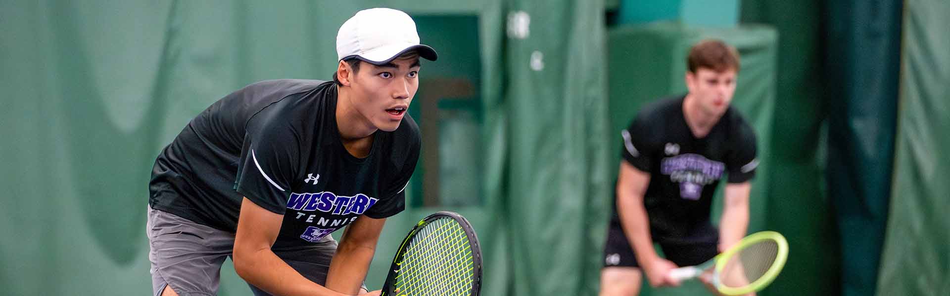 Western Mustangs men’s tennis player holding ball and racket