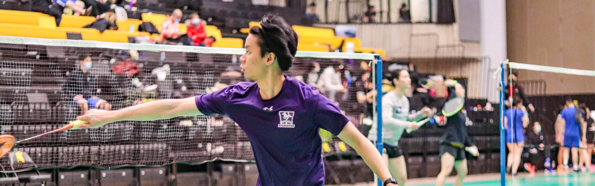 Western Mustangs men’s badminton player reaching for the birdie