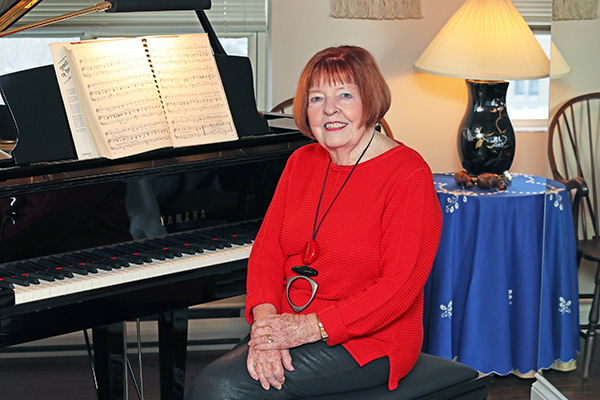 Dorothy sits at the piano