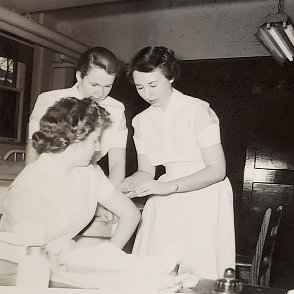 Susan Finley, right, reenacting a hypodermic injection on a fellow classmate